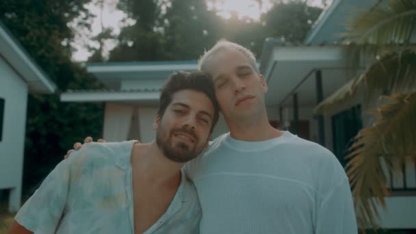 Una giovane coppia gay compra una nuova casa. Gli uomini gay felici si abbracciano davanti alla loro casa appena acquistata. Clienti entusiasti che acquistano un immobile o un appartamento. — Video Stock