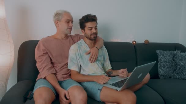 Couple gay faisant des achats en ligne à l'aide d'un ordinateur portable et carte de crédit — Video