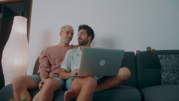 Couple gay faisant des achats en ligne à l'aide d'un ordinateur portable et carte de crédit — Video