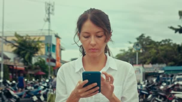거리에서 스마트폰으로 타자를 치는 젊은 여자의 모습 — 비디오