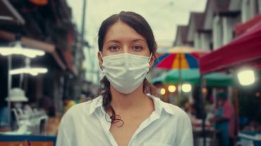 Sokak insanlarında koruyucu maske takan genç bir turist kadının portresi. konsept sağlık ve güvenlik.