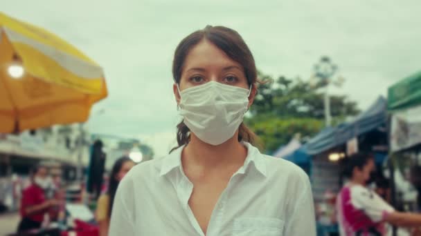 Portret van een jonge toeristische vrouw met een beschermend masker op de mensen van de straat. concept gezondheid en veiligheid. — Stockvideo