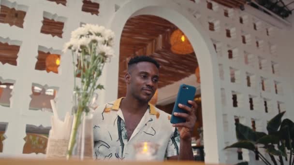 Giovane uomo afro-americano utilizza smartphone all'aperto — Video Stock