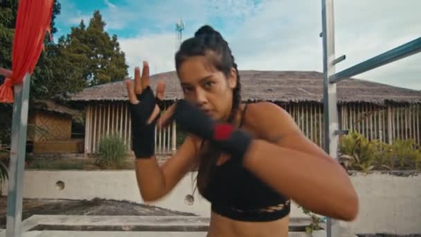 Женщина-боец тренирует свои удары, тренируется день в заброшенном отеле, сила подходит тело — стоковое видео