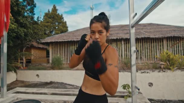 Женщина-боец тренирует свои удары, тренируется день в заброшенном отеле, сила подходит тело — стоковое видео