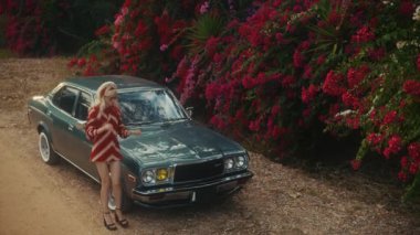 Sarışın Kafkas Kadın Tozlu Köy Yolu 'nda, Vibrant Red Bougainvillea' nın yanında, üzerinde