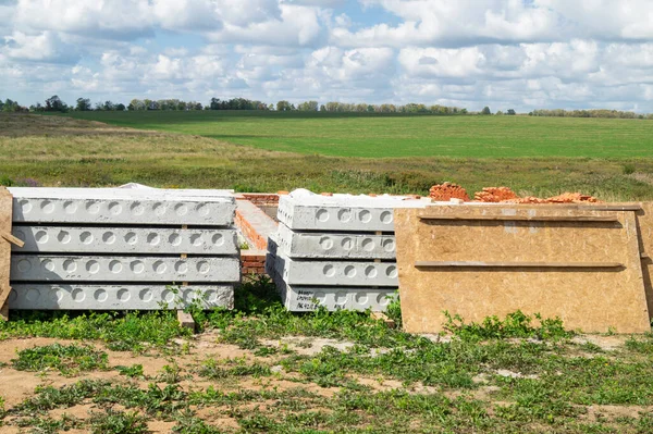 The Construction of the foundation for building in field on background blue sky. Year landscape at solar day