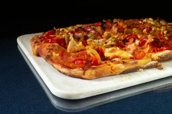 黒を基調としたソーセージとチーズのピザ テーブルの上で焼く 給餌の成果 — ストック写真
