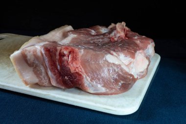 Beyaz tahtası olan domuz eti parçası masayı maviye boyadı. Beslenmenin siyah arka plandaki ürünleri