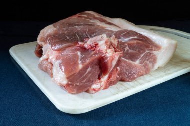 Beyaz tahtası olan domuz eti parçası masayı maviye boyadı. Beslenmenin siyah arka plandaki ürünleri