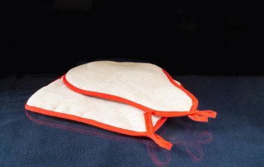 Mutfak tutacağı cam masanın üzerinde yansımalı duruyor. Siyah arkaplanda mutfak araçları