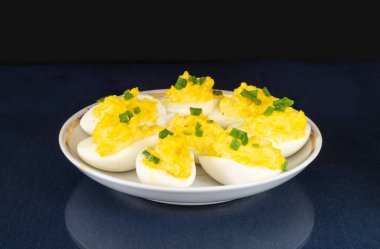 Masada mayonez ile doldurulmuş tavuk yumurtası. Beslenmenin siyah arka plandaki ürünleri