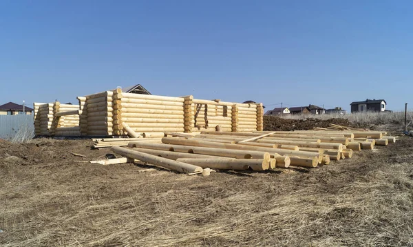 Construction of a wooden house on a sunny day in spring. New log house against the blue sky