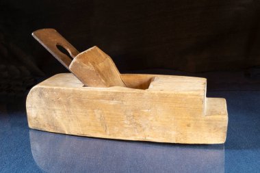 Masada yansıması olan eski bir ahşap uçak. Siyah arkaplanda marangoz aracı