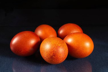 Masanın üzerinde yansıması olan boyalı tavuk yumurtaları. Siyah arkaplanda yemek