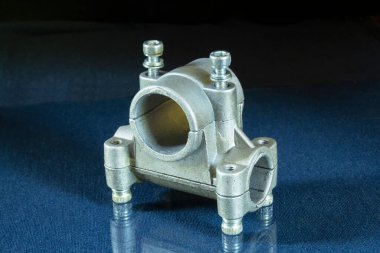 Masaya yansıtmalı metal boru klipsi. Koyu arkaplandaki parçaları onar