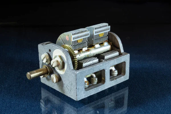 Değişken kapasitör yansıma ile birlikte masada yatıyor. Siyah arkaplanda elektrik parçaları