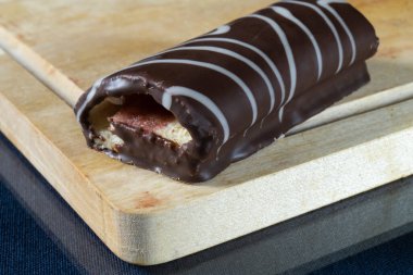 Mutfaktaki ahşap bir tahtanın üzerinde tatlı bir rulo. Gıda ürünleri siyah arka planda