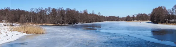 Paysage avec gelé par la rivière sur fond bleu ciel — Photo