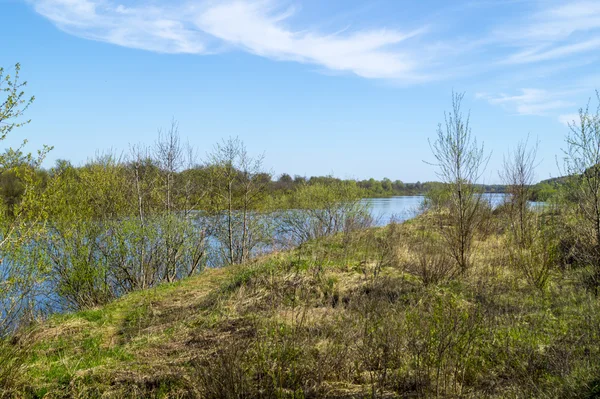 Paysage printanier avec rivière sur fond bleu ciel — Photo