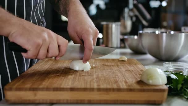 Zbliżenie Cook Man Ręce Cut White Cebuli na plastry z nożem na desce do cięcia — Wideo stockowe