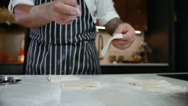 Großaufnahme Bäcker Hand Kochen Teig in fallendem Mehl auf Schneidetisch in der Küche — Stockvideo