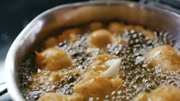 Yakından bakınca aşçının kızgın yağda pişirdiği kızartma yemeği Demir Tavada kaynatıyor. — Stok video