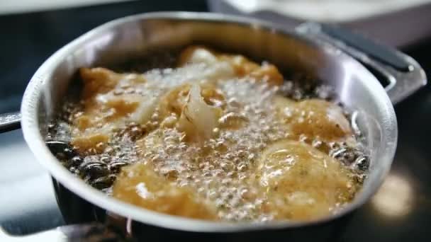Primer plano Ver Chef cocinar alimentos fritos en masa en aceite caliente hirviendo en sartén de hierro — Vídeo de stock