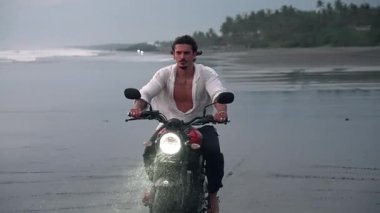 Motosikletli Sürücü ya da Sahilin Güzel Doğasında Seyahat. Moto Bisikletli Çekici Yarışçı Motorlu Kum Kumu ile Hızlı Hareket Ediyor. Motosiklet Gezisinde Yetişkin Özgürlüğü