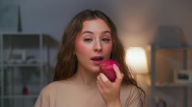 Sağlıklı Yemek Yiyen Genç Kadın 'ın portresi Kameraya Yakından Bakıyor. Vegan, Kırmızı Elma Renkli Gevşetici Isırıyor. Olgun Çiftlik Muamelesi İçerisi İçi İçi İçin İştahlı Kadın Konsepti