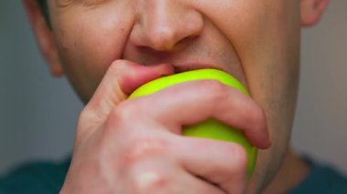 Kamerada Sağlıklı Yemek Yiyen Genç Adam 'ın portresi. Vegan Kişinin Ekin Yüzü Yeşil Elma ve Neşe İçinde Rahatlamanın keyfini çıkarıyor. Stüdyo Aydınlatma 'da Olgun Çiftlik İkramlı Açlık Adamı İştahı