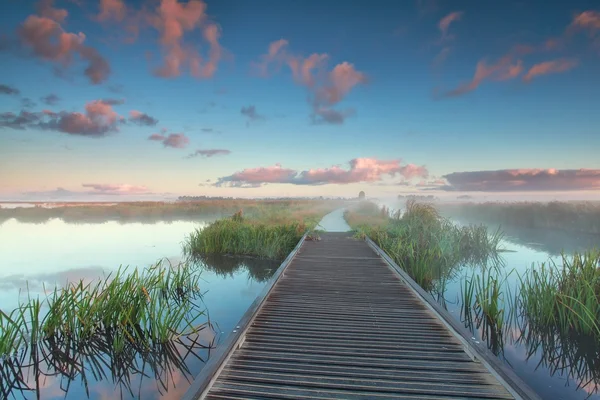 Holzradweg auf dem Wasser bei Sonnenaufgang — Stockfoto