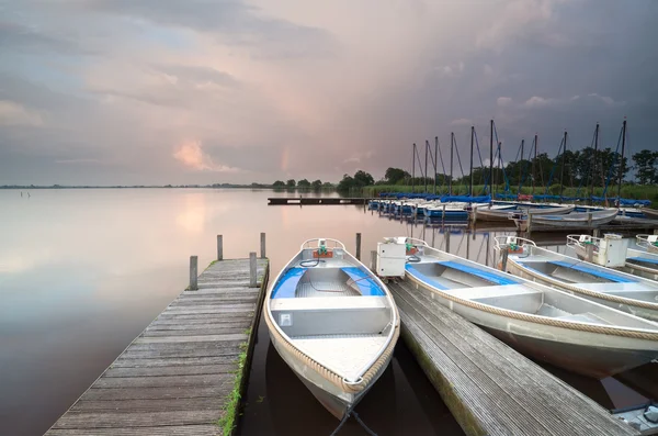 Barcos e iate por cais em grande lago — Fotografia de Stock