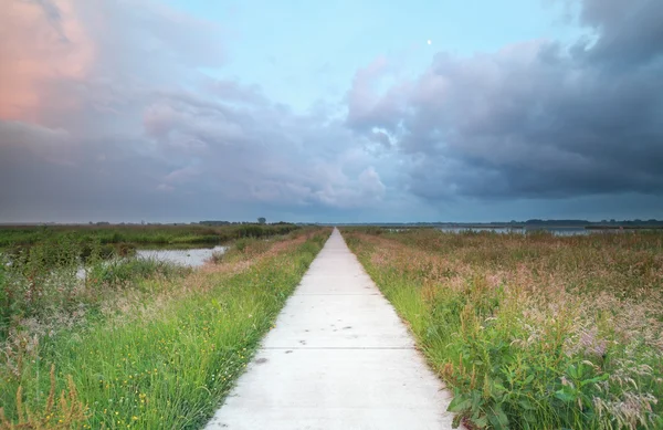 Długo rowerów road ar sunset — Zdjęcie stockowe