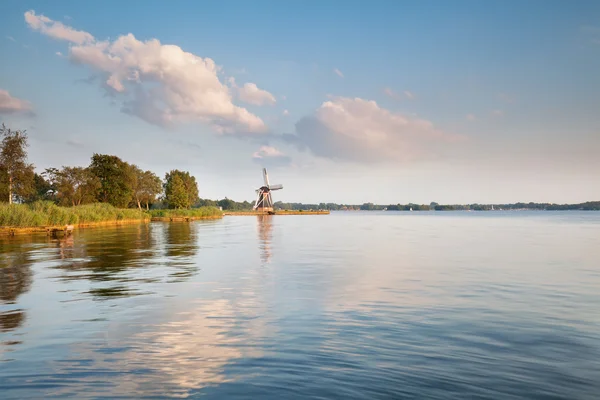 Büyük göl ve mavi gökyüzü tarafından yel değirmeni — Stok fotoğraf