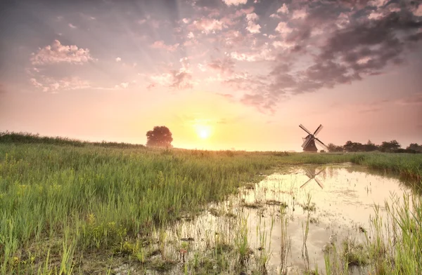 Beautiful summer sunrise over windmill by river — Stock Photo, Image