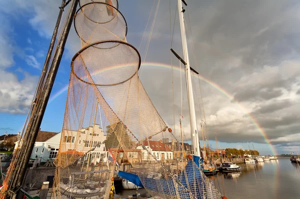 Stor regnbue over havn med fiskebåter – stockfoto