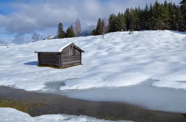 Oude houten hut op besneeuwde Alpen weide — Stockfoto