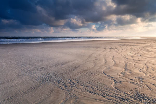 Salida del sol sobre la playa de arena del mar del Norte — Foto de Stock