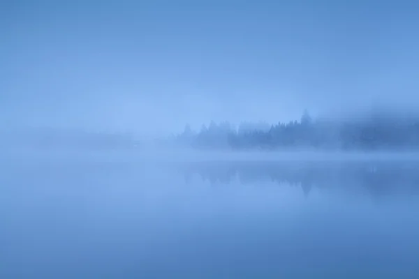 Hustá mlha nad jezerem v Alpách — Stock fotografie