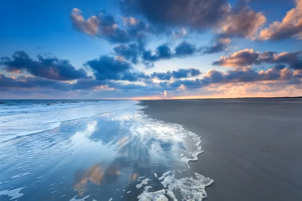 Paisaje nuboso reflejado en el mar al amanecer — Foto de Stock