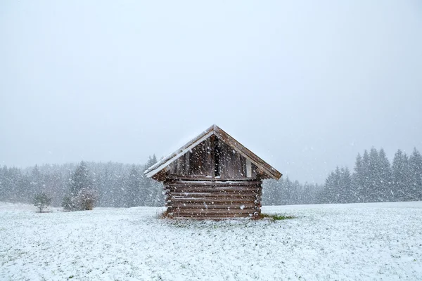 Vieja choza de madera en tormenta de nieve — Foto de Stock