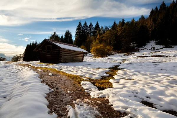 Trä alpstuga i solnedgången ljus — Stockfoto