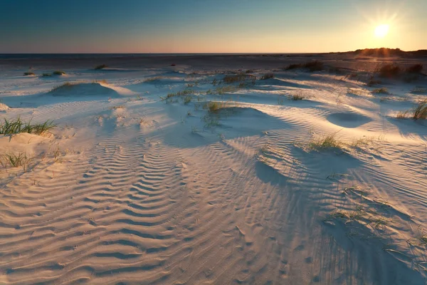 Lever de soleil sur les dunes de sable sur la côte — Photo