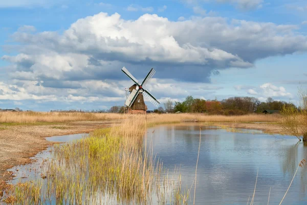 Molino de viento holandés sobre cielo azul por río —  Fotos de Stock