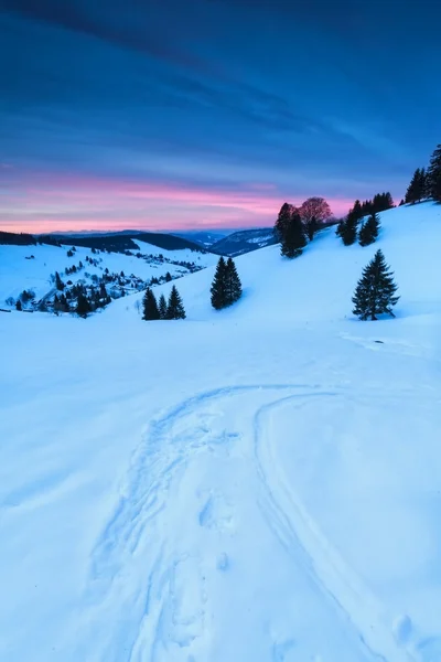 Pista de esquí en la nieve en las montañas al amanecer — Foto de Stock