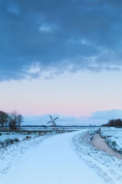 Maneira de moinho de vento na neve ao nascer do sol — Fotografia de Stock