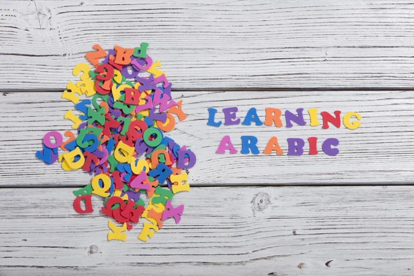 The colorful words arabic made with colorful letters over white wooden board — Stock Photo, Image