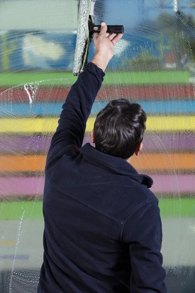 Window cleaner using a squeegee to wash a window — Stock Photo, Image