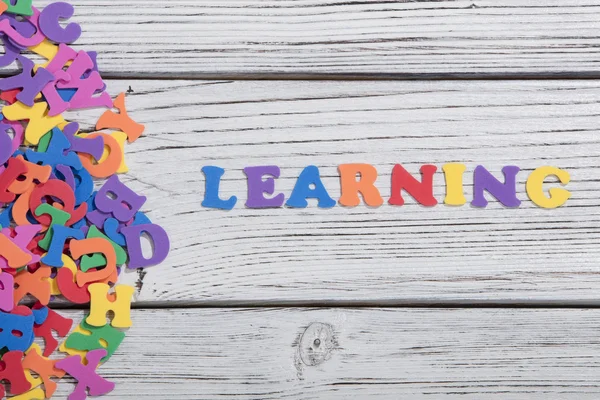 The colorful words learning made with colorful letters over white wooden board — Stock Photo, Image